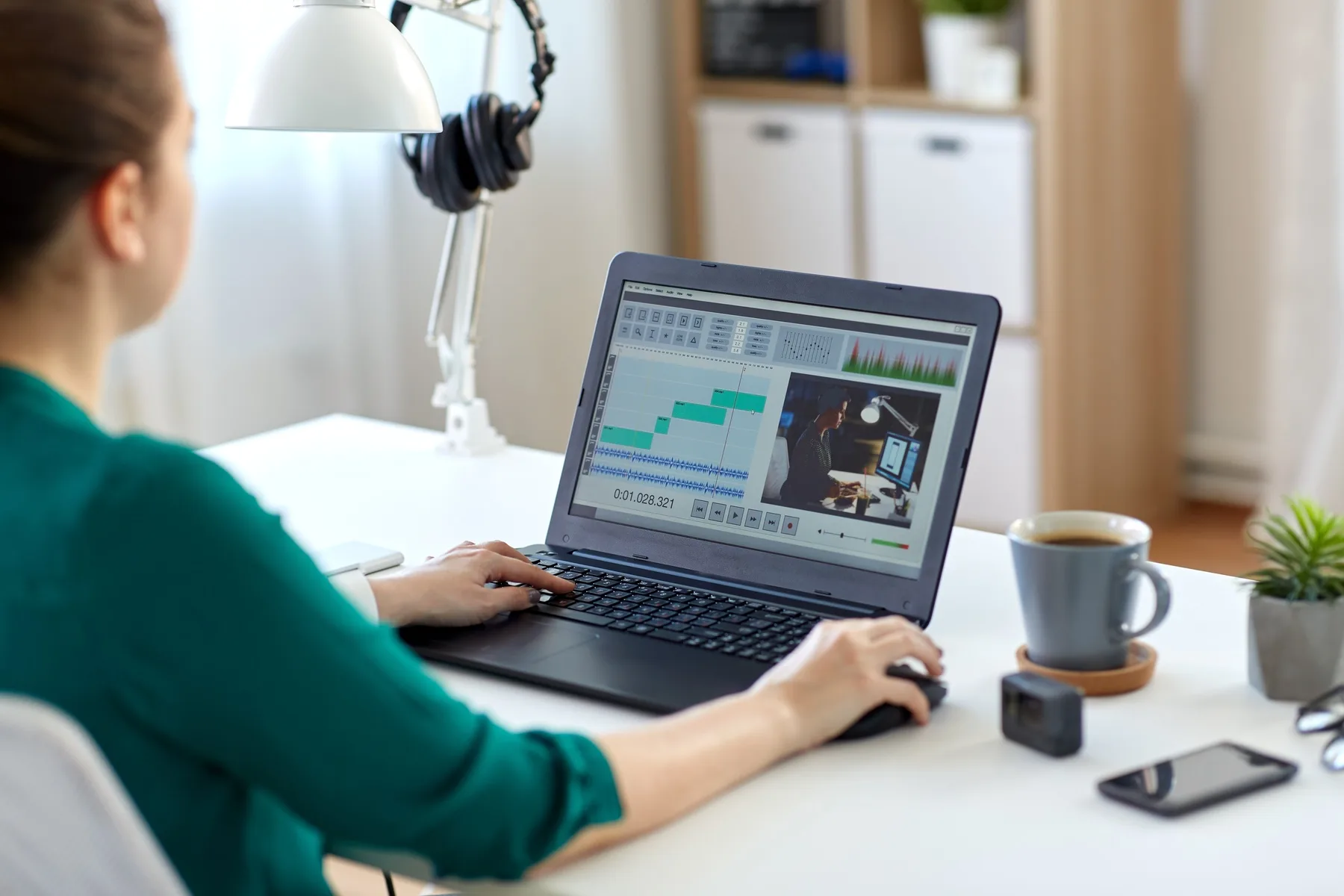 A marketer editing a video timeline on a laptop at a home office desk