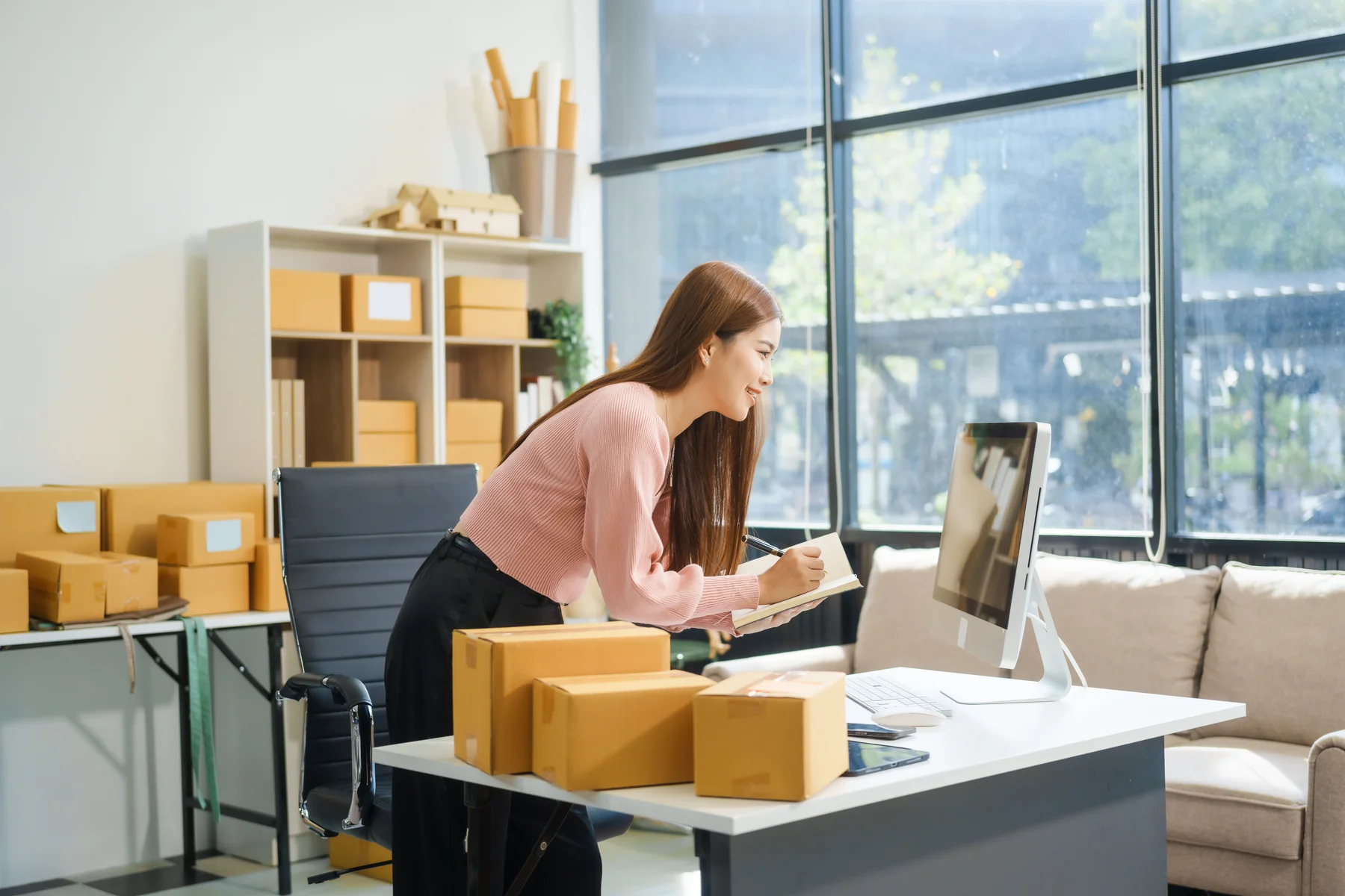 A small business owner reviewing online sales and marketing performance on her desktop computer