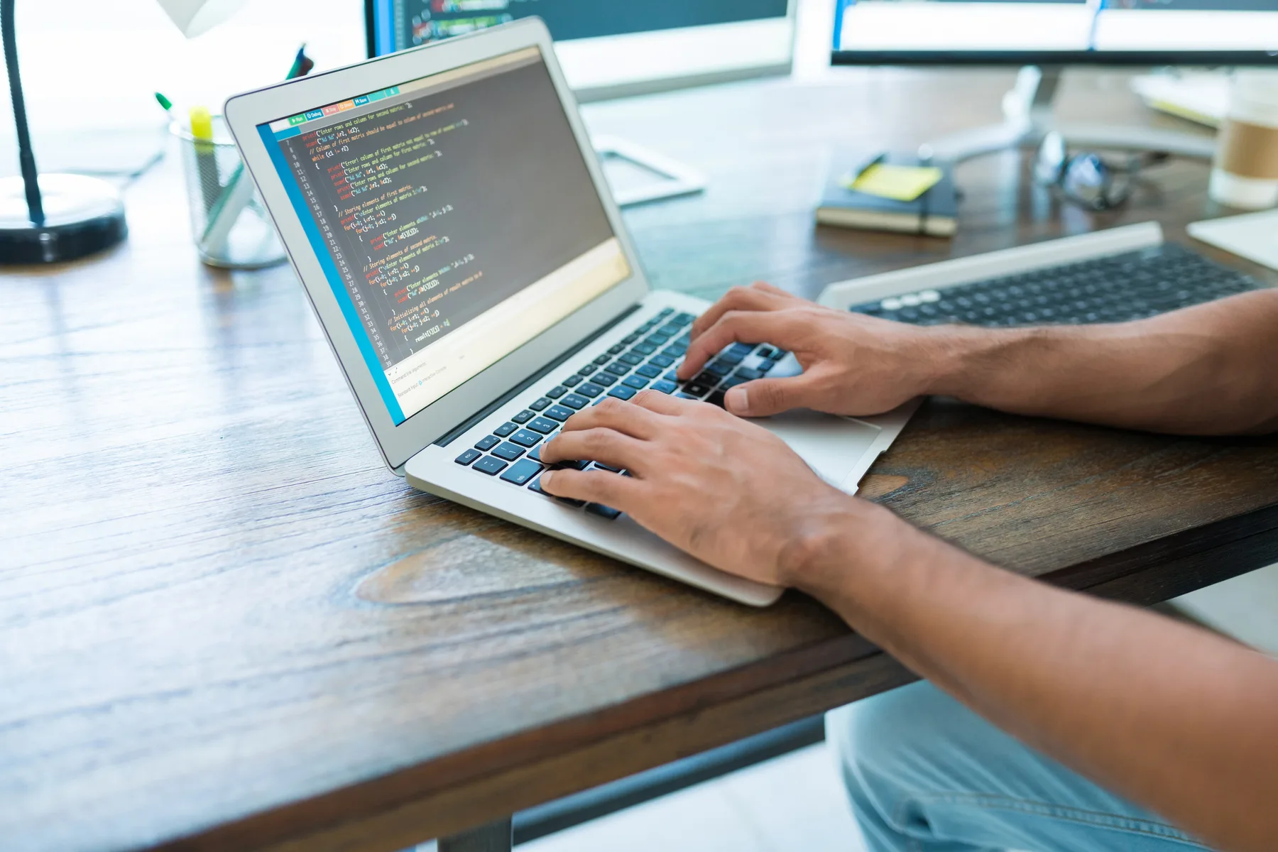 A developer working on a laptop in a modern office workspace