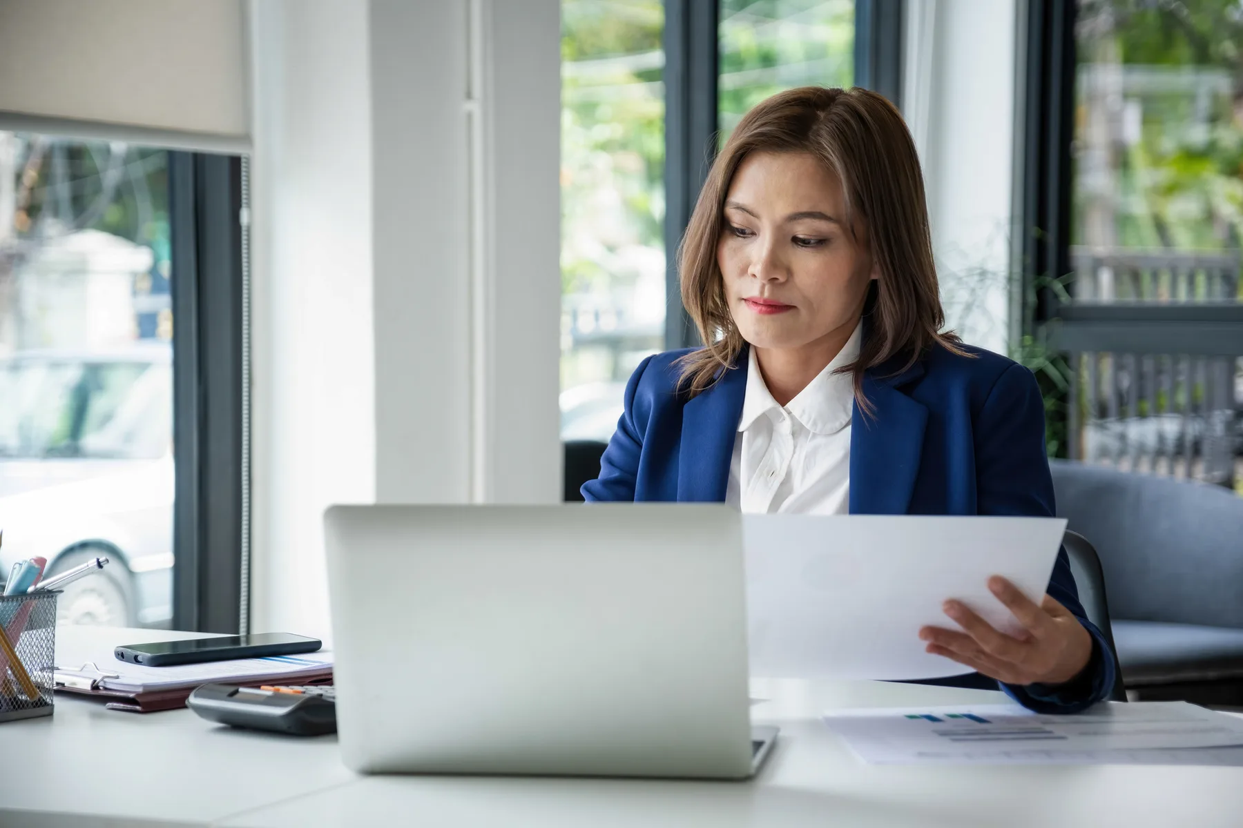 A small business owner planning recurring work tasks at a laptop in a home office
